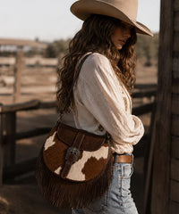 Trinity Ranch Cowhide Saddle Bag — genuine leather with cowhide print and fringe